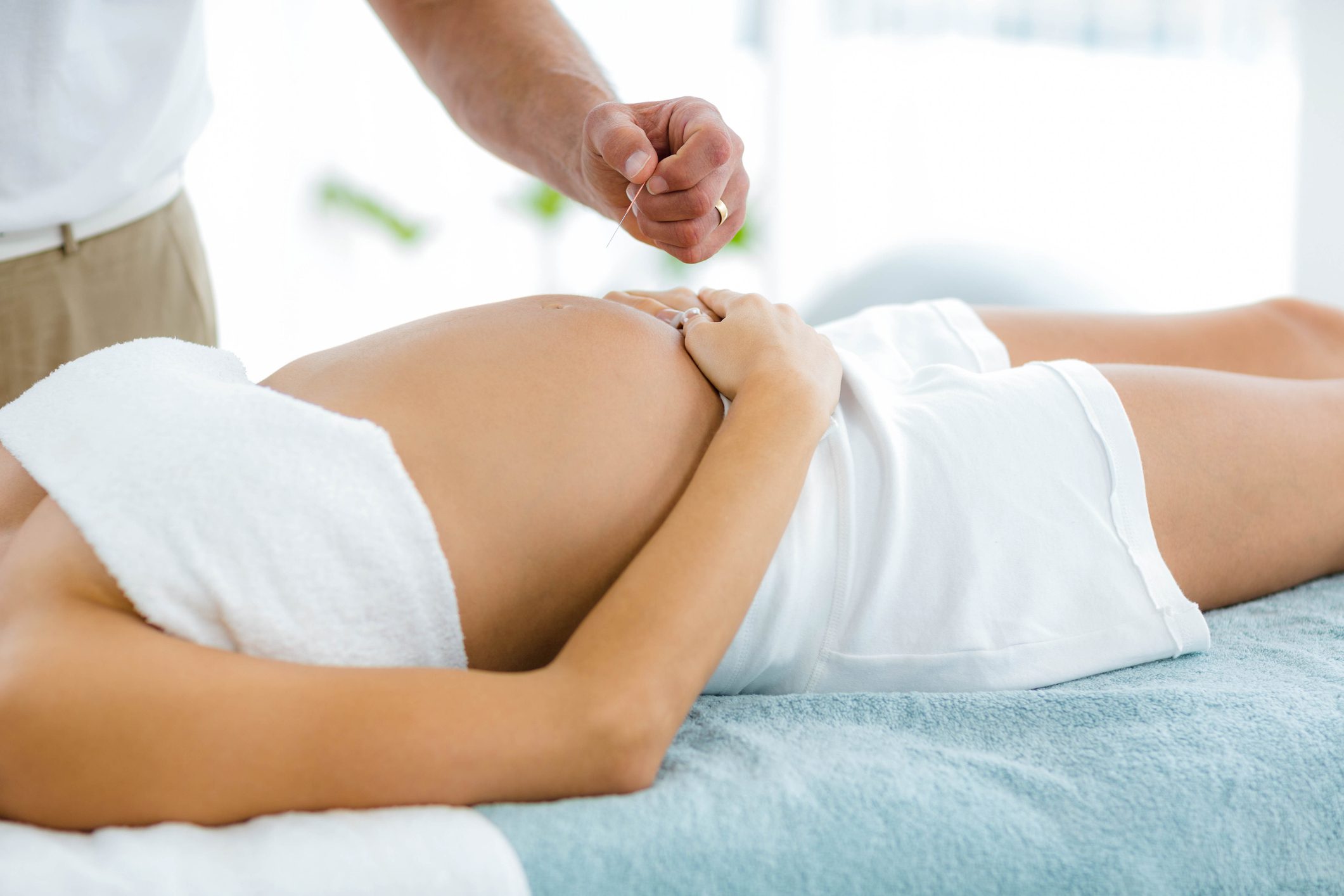 Pregnant woman receiving a spa treatment from masseur Acupuncture in Walnut Creek Ca