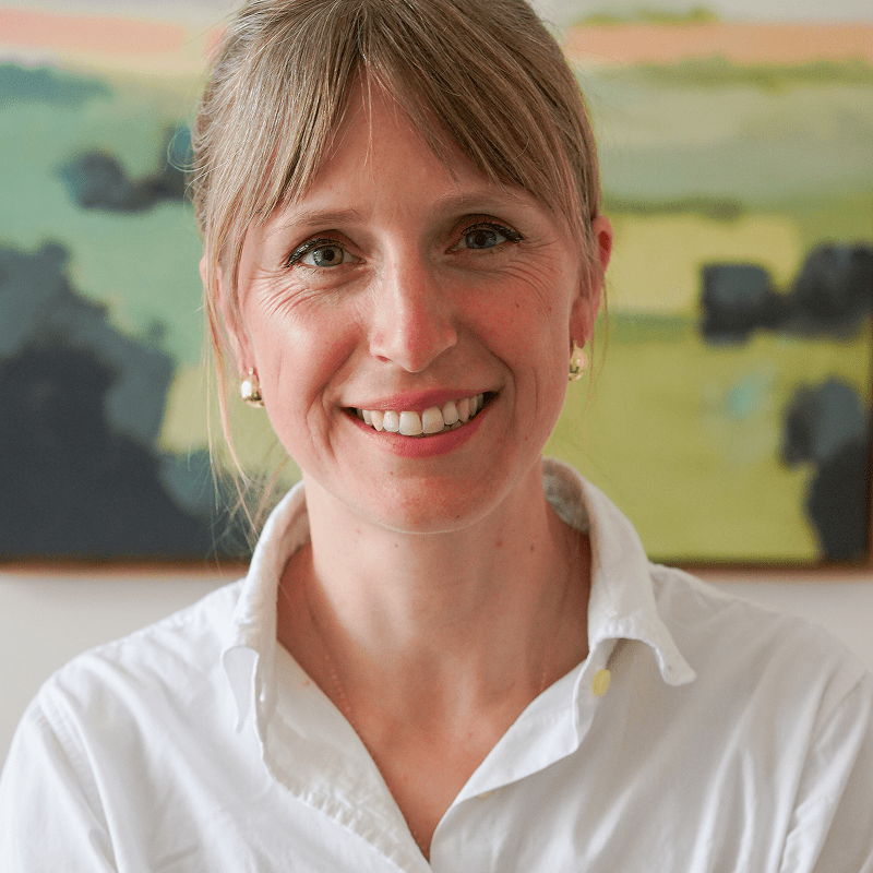 Smiling person in front of abstract painting.