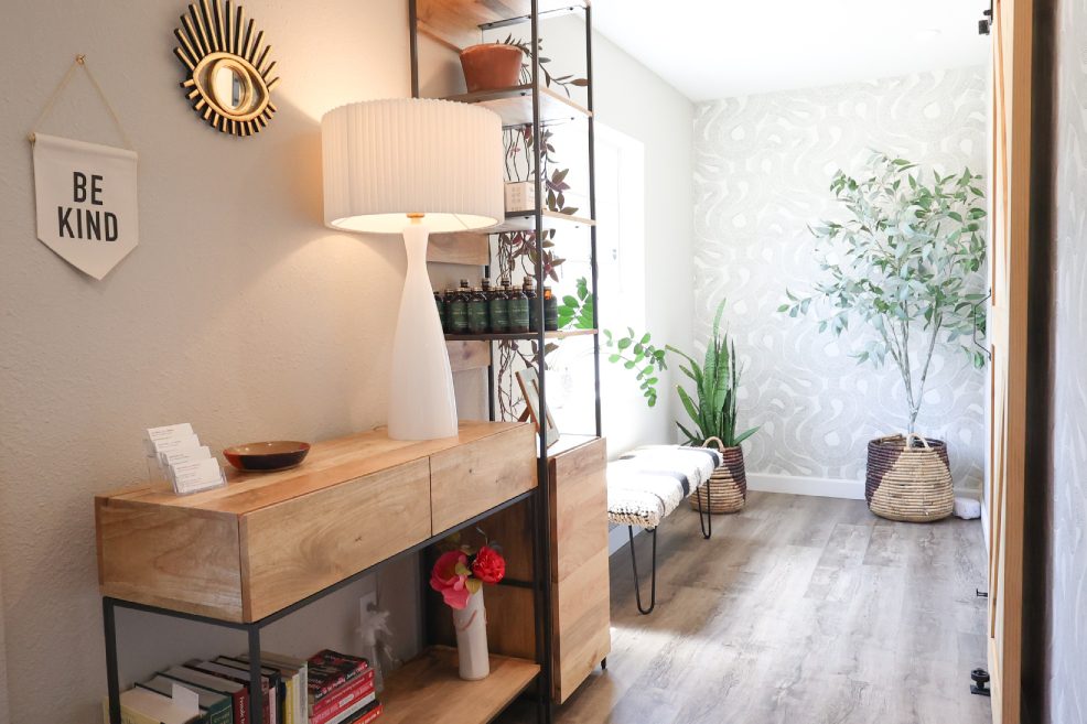 Modern hallway with plants and wooden furniture.